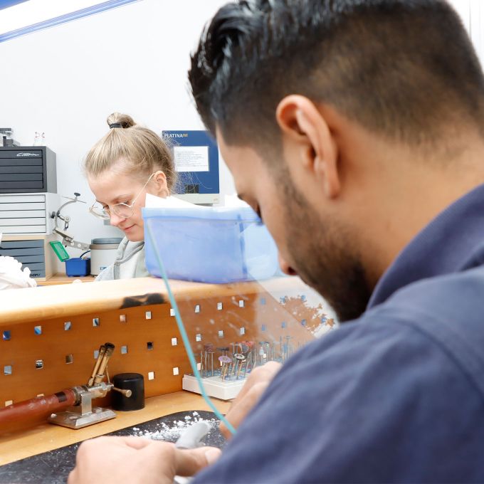 Foto: Dentaltechniker und Kollegin bearbeiten im Labor Zahnprothesen